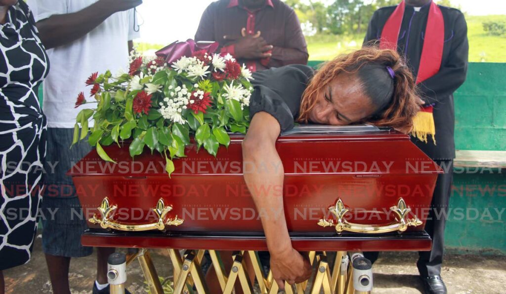 Christinna Ramdial clutches the coffin during the funeral of her three-year-old son Allon at the Ortoire Cemetery, Mayaro on Sunday. The toddler drowned in a river on December 9. Photo by Lincoln Holder