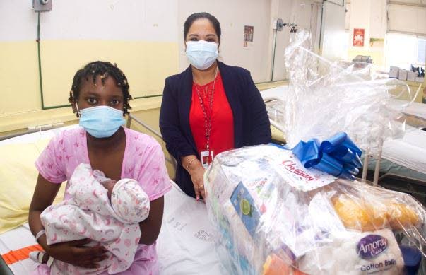 Mya Baldeo holds her baby at the San Fernando General Hospital on Sunday. Photo courtesy SWRHA