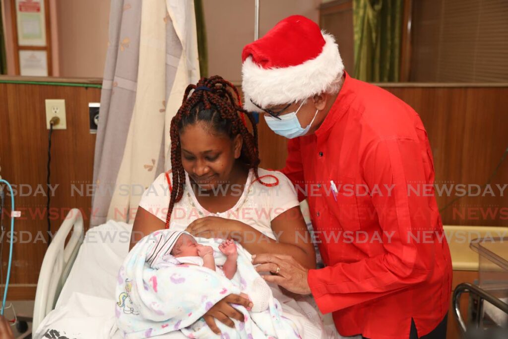 Minister of Health Terrence Deyalsingh with Athena Yee Kin Chung who gave birth to a baby girl named Dasia Guerra at the Port of Spain General Hospital on Christmas Day. - JEFF K MAYERS