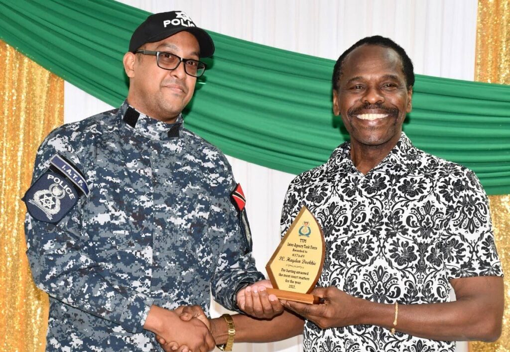 JOB WELL DONE: PC Hayden Dookie receives an award from National Security Minister Fitzgerald Hinds during the latter's Christmas Day visit to the San Juan headquarters of the Inter-Agency Task Force and Guard and Emergency Branch. PHOTO COURTESY MINISTRY OF NATIONAL SECURITY 