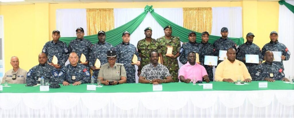 National Security Minister Fitzerald Hinds, seated centre, with IATF, GEB and Defence Force officers (all standing) who received awards during Hinds' visit on Christmas Day.