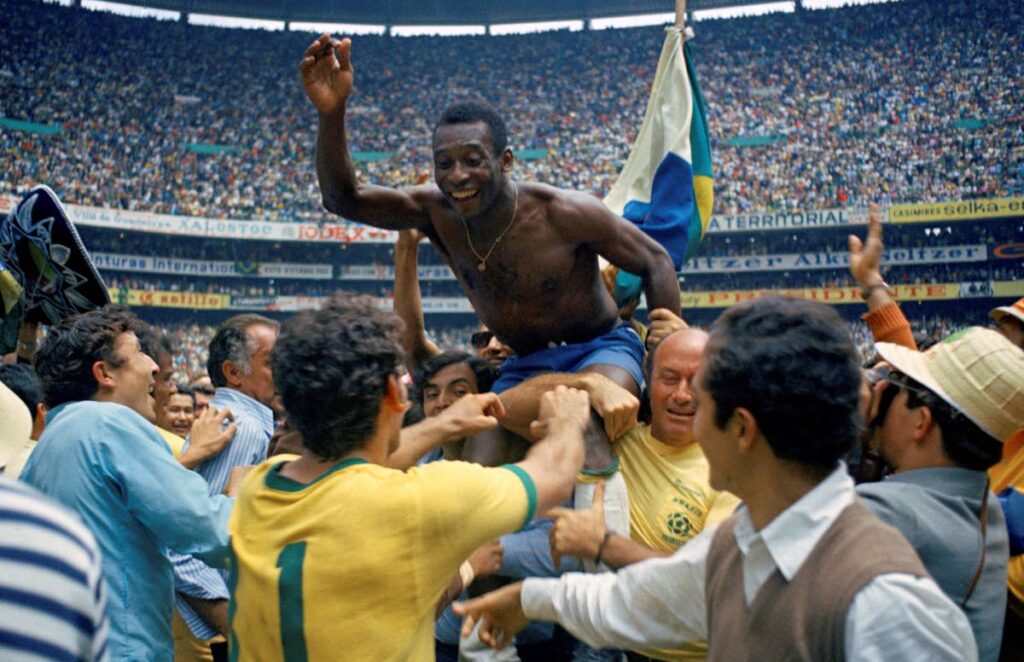 FLASHBACK: Brazil's Pele is hoisted on the shoulders of his teammates after Brazil won the World Cup final against Italy, 4-1, in Mexico City's Estadio Azteca, June 21, 1970.  Pelé, the Brazilian king of football who won a record three World Cups and became one of the most commanding sports figures of the last century, died in sao Paulo on Thursday. He was 82. (AP Photo) - 