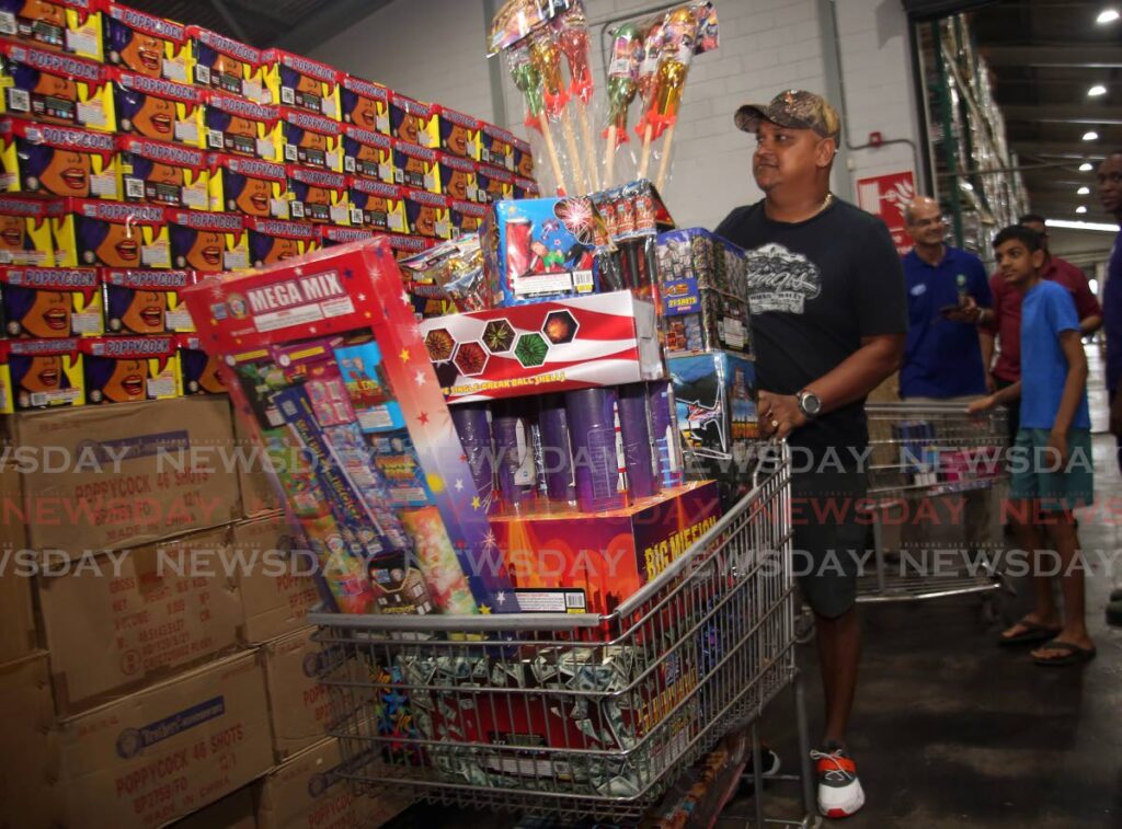Randy Goonraj with a trolley full of fireworks at FireOne Fireworks warehouse in Macoya, on Friday. - SUREASH CHOLAI