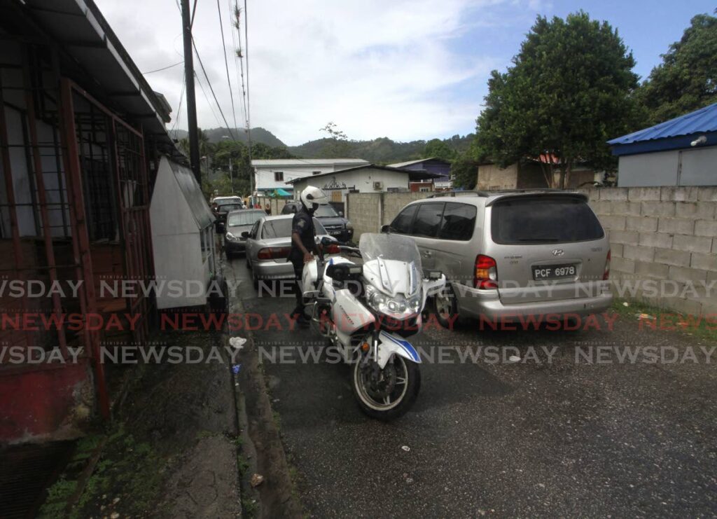 A policeman at the scene where  Salim Abdullah Muwakil was found shot dead in his home at Green Drive, Diego Martin. - ANGELO MARCELLE