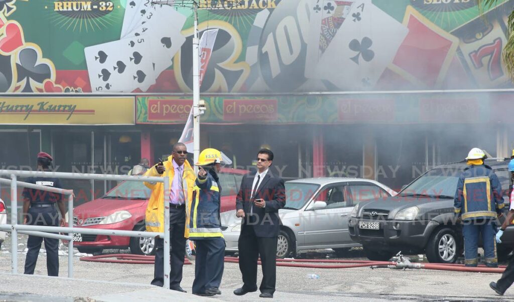 FILE PHOTO: Then health minister Dr Fuad Khan speaks to a fire officer in front of an El Pecos restuarant at Royal Palm Hotel, Maraval, soon after an explosion at the restaurant on February 5, 2015.  
