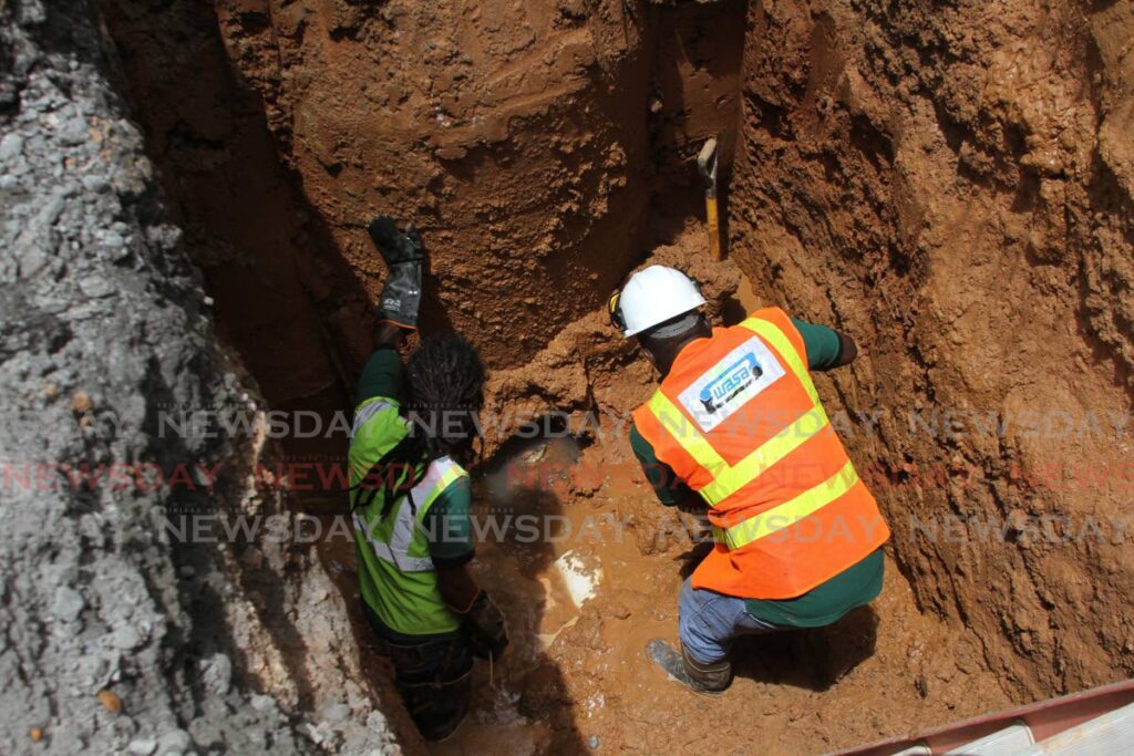 WASA workers carry out repairs on a corroded sewer line. - MARVIN HAMILTON