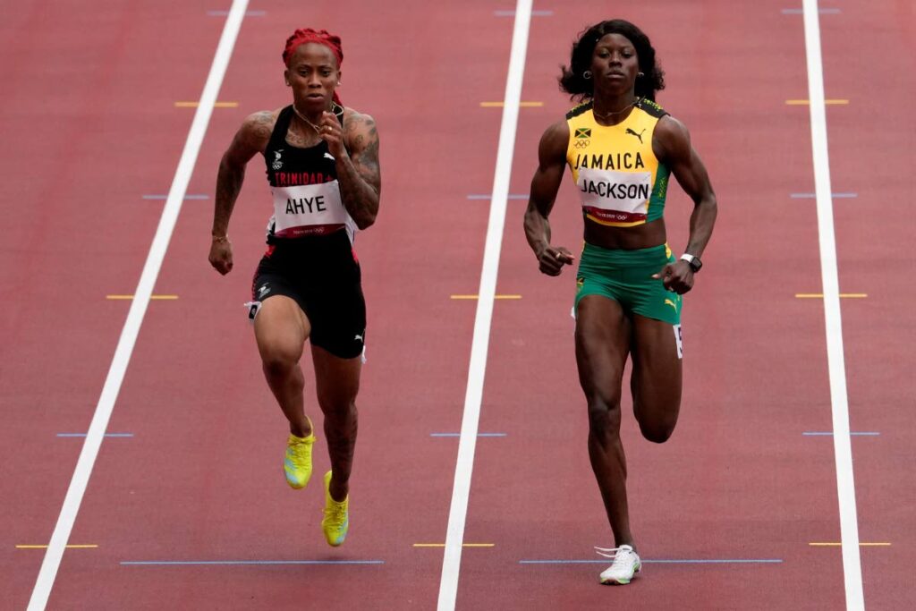 Michelle-Lee Ahye, left, wins a heat in the women's 100-metre run at the 2020 Summer Olympics, on July 30, 2021, in Tokyo. (AP PHOTO) - 