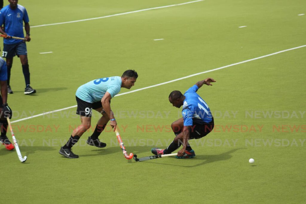 In this July 23, 2017 file photo, Queen's Park's Raphael Govia (left) tries to pass Defence Force's Neil Lashley at the TT Hockey Board's Veterans Tournament at the National Hockey Centre, Tacarigua. - 