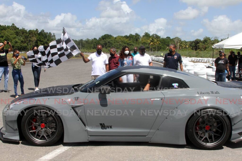 File photo: Minister of Youth Development and National Service Foster Cummings waves the checkered flag while, to his left, Minister of Agriculture, Lands and Fisheries Clarence Rhambharat looks on at the TTASA's Memorial Day, at the Frankie Boodram Wallerfield International Raceway. 