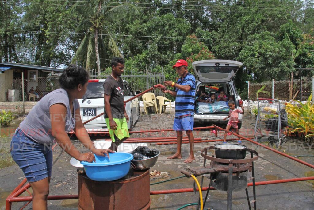 In this file photo, residents of Molly Street, Debe had to resort to ccoking meals in the road after their homes were flooded in October, last year. - File photo/Marvin Hamilton