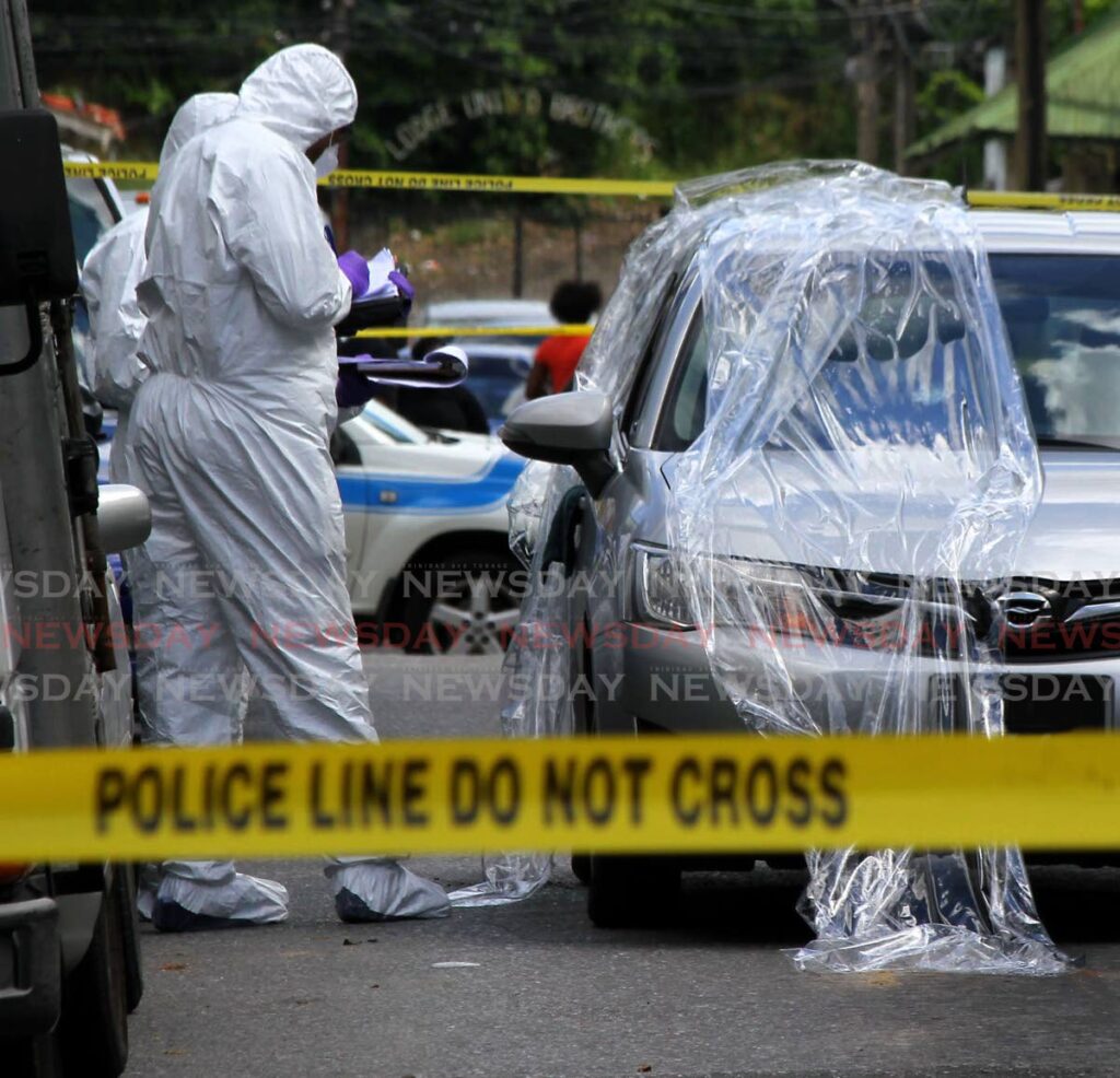 In this file photo, crime scene unit investigators gather clues after a shooting incident in downtown Port of Spain. - File photo/ROGER JACOB