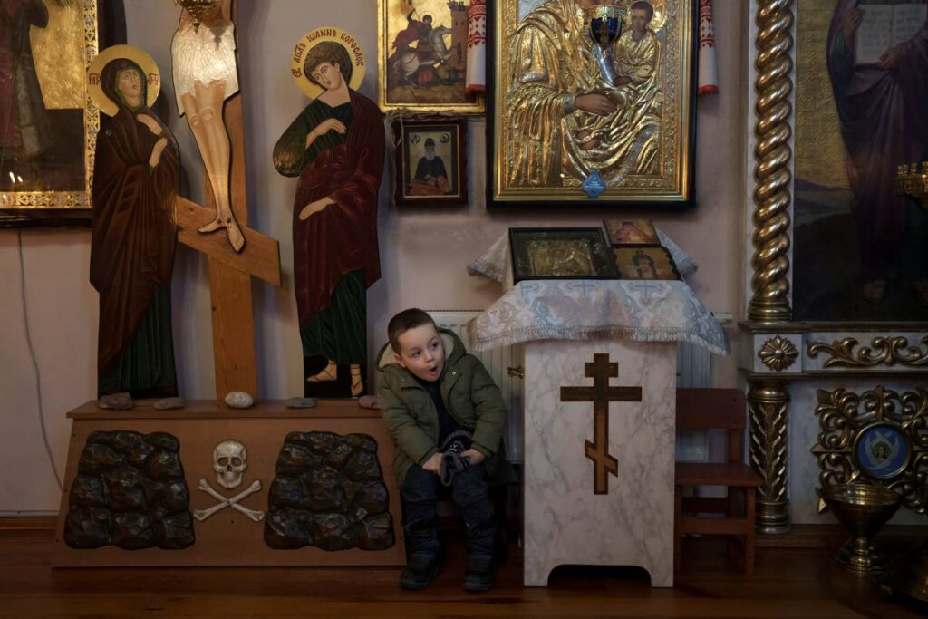 A boy attends a Christmas Day Mass at an Orthodox church in Bobrytsia, on the outskirts of Kyiv, Ukraine, on  December 25, 2022. AP Photo - 