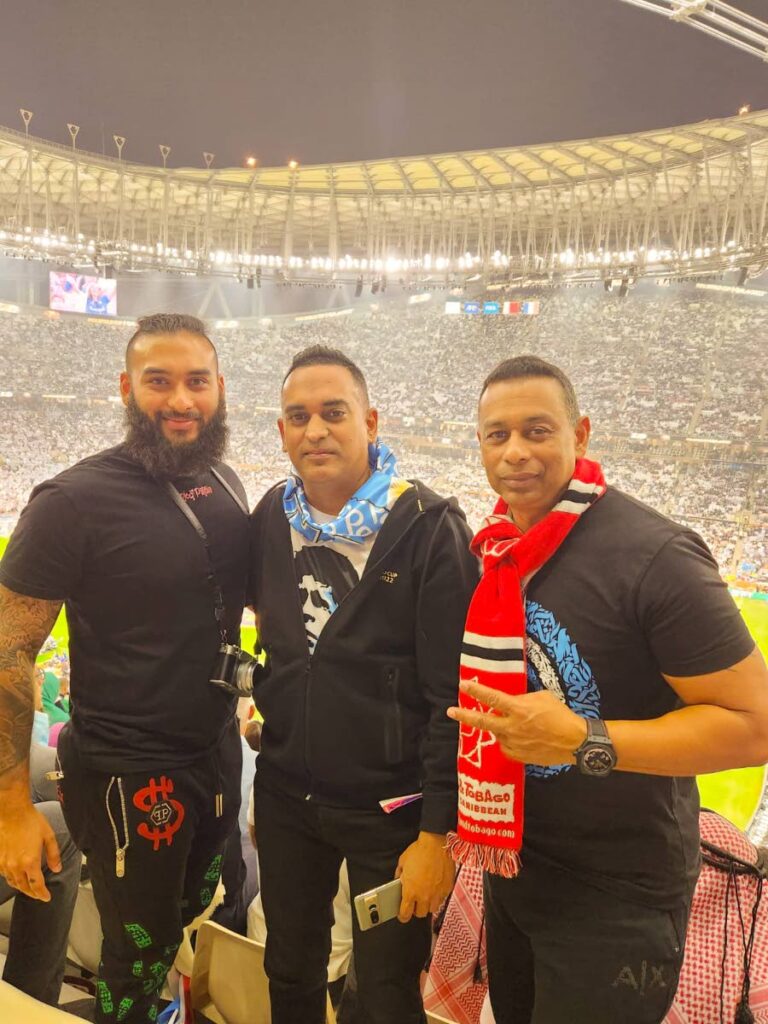 TT Football Federation media officer Shaun Fuentes (centre) with Trinidadians Sham and Armis Mohammed at the final of the FIFA World Cup 2022, in the Souq Waqif, Qatar. PHOTO COURTESY SHAUN FUENTES - 