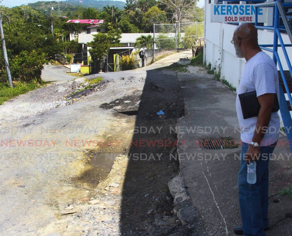 FIX THIS ROAD: Resident Wayne Joseph looks at a section of the rapidly deteriorating Caratal Road on Monday. File Photo by Lincoln Holder