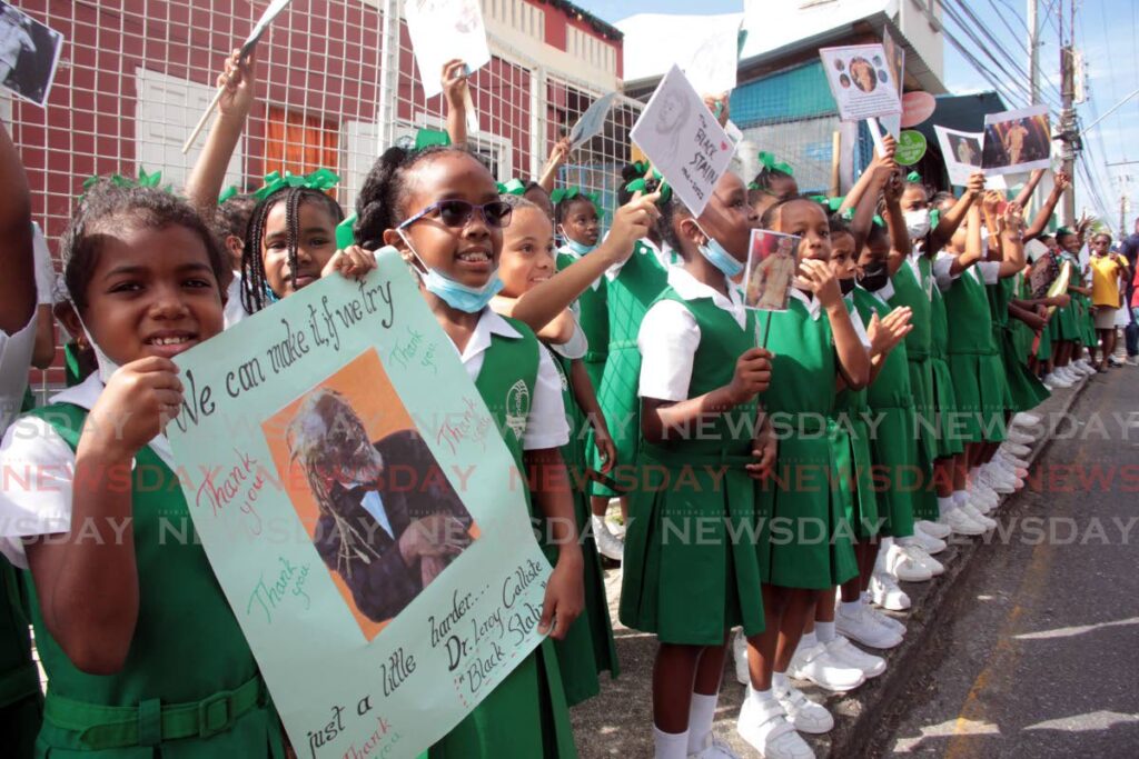 Pupils from  St Gabriel's Girls RC School line the Dr Leroy Calliste Street in San Fernando for funeral procession for the Black Stalin  en route to the Southern Academy for the Perfroming Arts (SAPA) for the funeral service. - Lincoln Holder