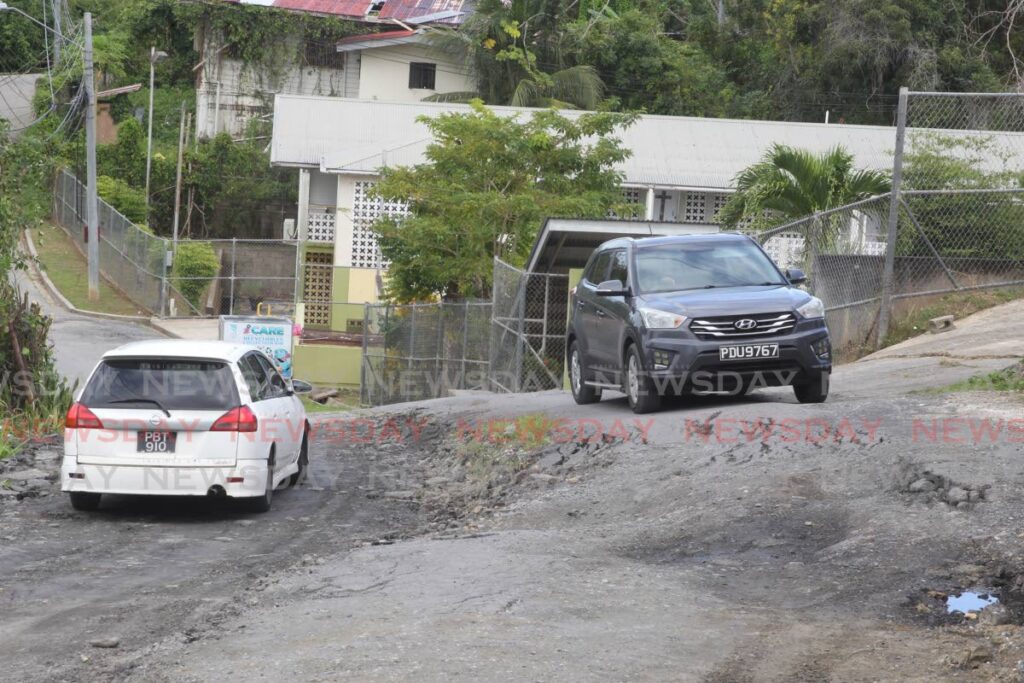 Vehicles move once again on the partially repaired Caratal Main Road on Friday. Photo by Marvin Hamilton