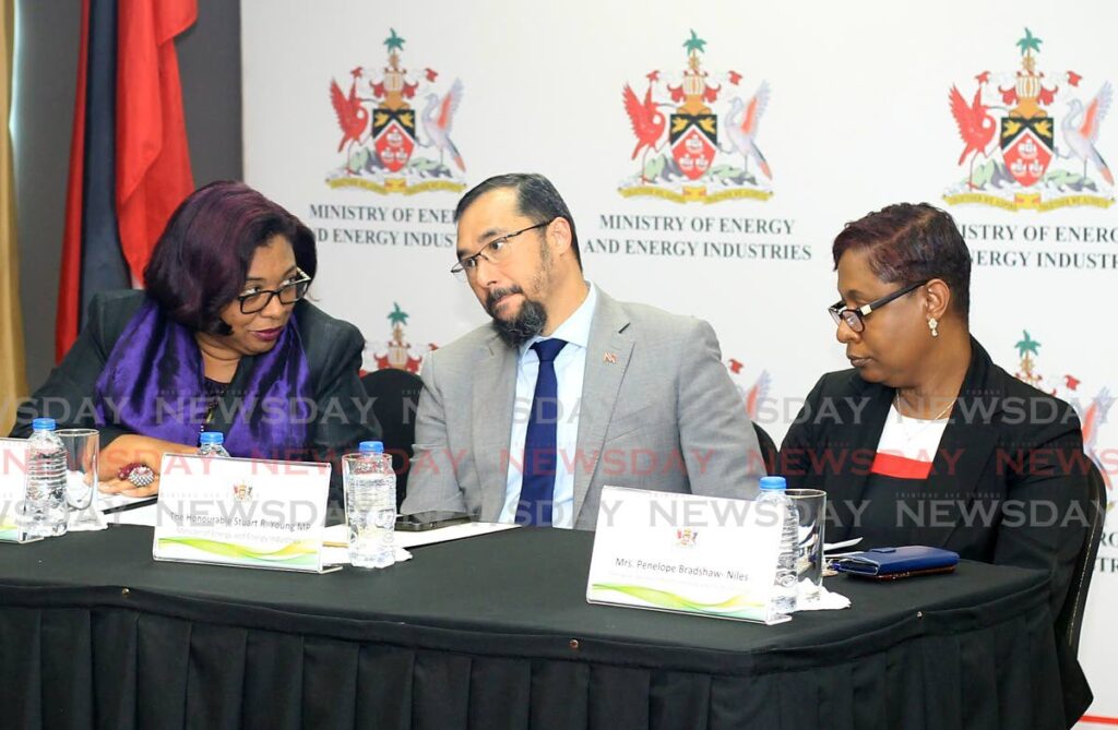 Energy Minister Stuart Young listens closely to acting permanent secretary Sandra Fraser and permanent secretary Penelope Bradshaw-Niles during opening of onshore/neashore bids at the ministry in Port of Spain on Monday. - ROGER JACOB