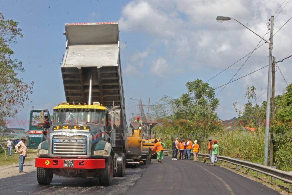 A contractor offloads asphalt at Golconda Connector Road in south Trinidad where the Ministry of Works and Transport carried out remedial works on Sunday. Photo by Marvin Hamilton