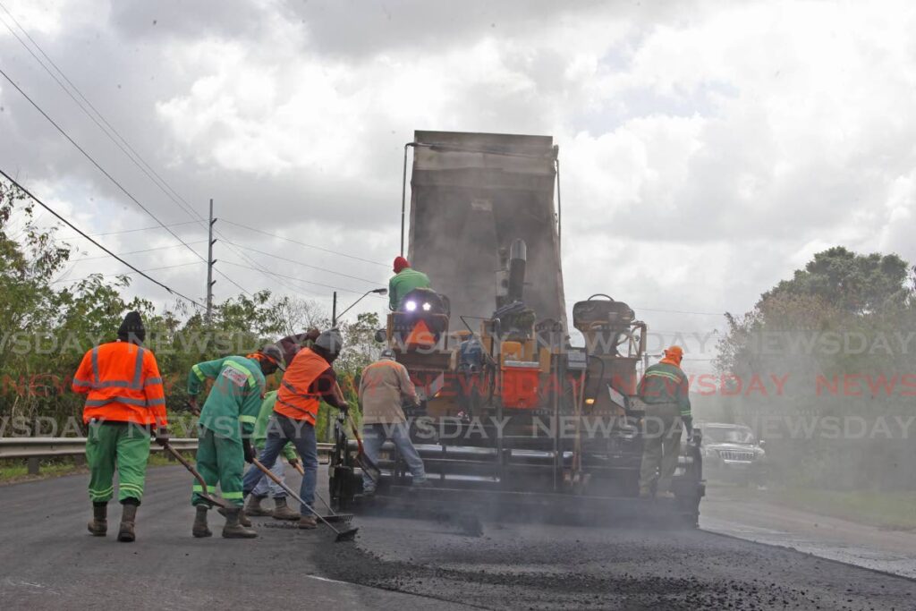 A crew from the Ministry of Works and Transport makes repairs to the Golconda Connector Road on Sunday. - Marvin Hamilton