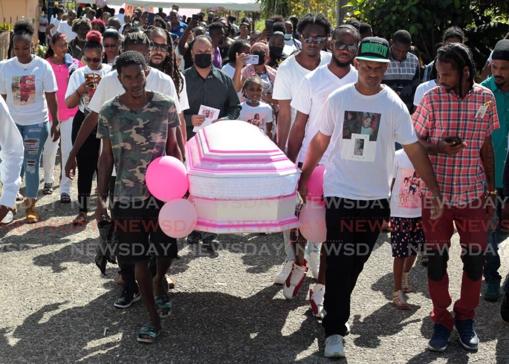Kylie Meloney's coffin is carried to the hearse after a service at her family's Quash Trace, Sangre Grande home on Wednesday. - ROGER JACOB