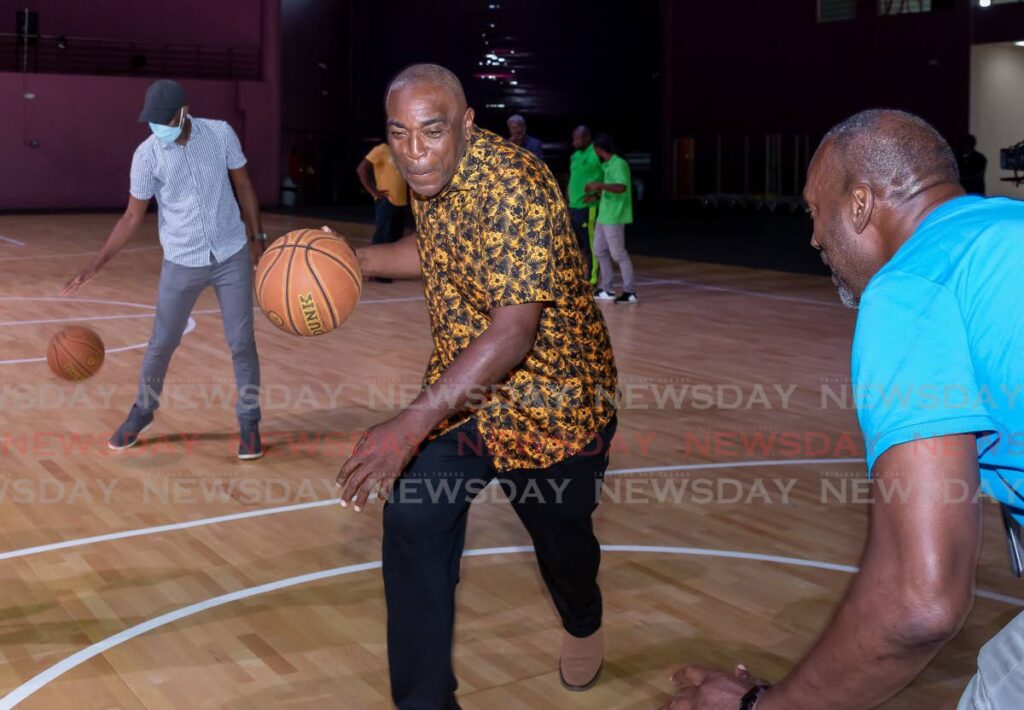 Assemblyman Wane Clarke, centre, drives to the basket as he tests the new indoor sport floor at Shaw Park Cultural Complex on Friday. Photo by David Reid