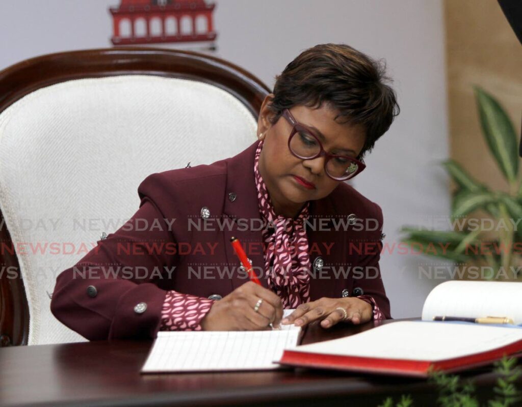 I ACCEPT: President-elect Christine Kangaloo signs the instrument of appointment on Thursday at the Red House Rotunda. Photo by Angelo Marcelle