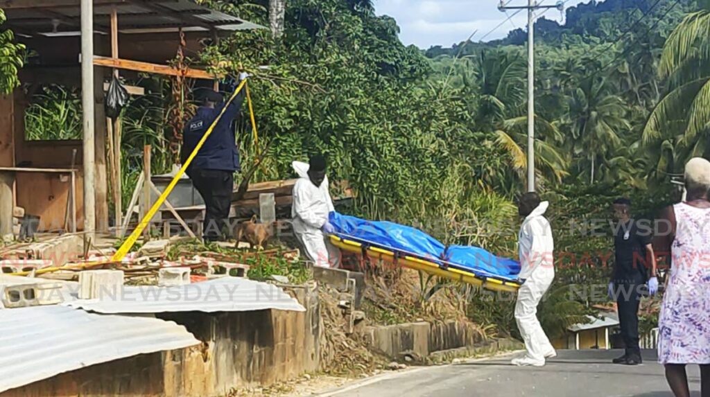 TAKEN AWAY: Undertakers remove the body of one of two men who were gunned down at a construction site in Blanchisseuse on Friday. The victims were identified as Nigel Dedier and Michael Evangelist. Photo by Shane Superville