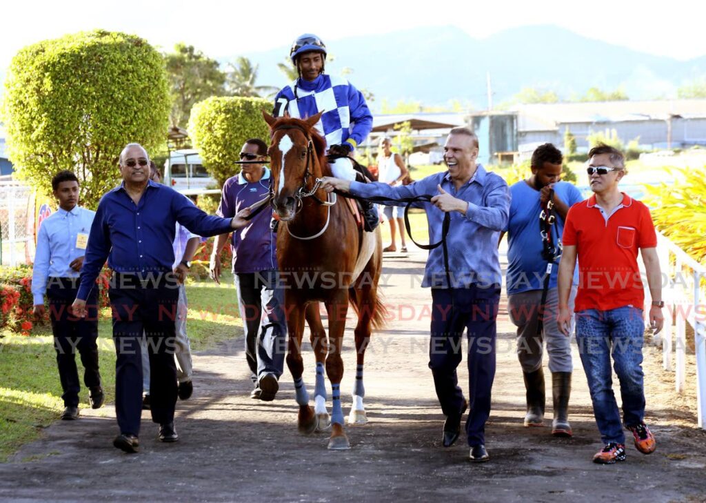 Winner of Race 6 General JN is led to the winner’s circle by owner Jerry Narace, third from right), on Saturday, 
on Day 1 of the local horse racing season, at 
Santa Rosa Park, Arima.  - SUREASH CHOLAI