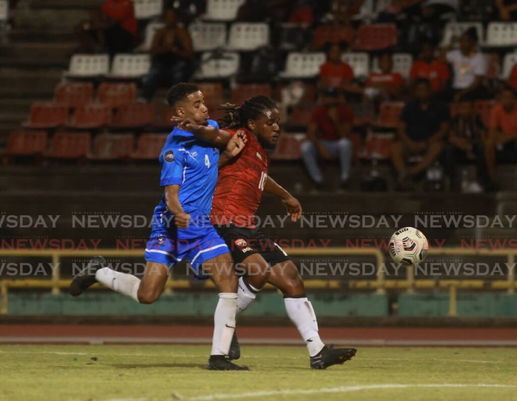 TT’s Duane Muckette (R)  holds off St Martin’s Donovan Fils-Aime during a frienldy 
international at the Hasely Crawford 
Stadium, Mucurapo, on Sunday.  - Nicholas Bhajan