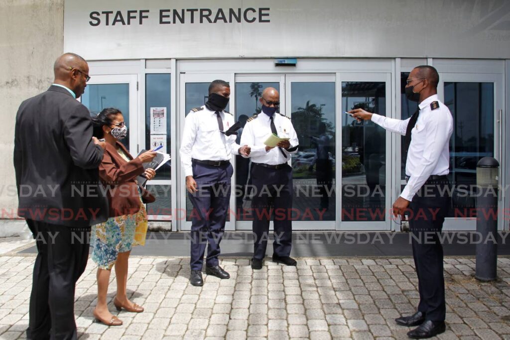 In this file photo, Transport Commissioner Clive Clarke, right, chats with other licensing officers at the Caroni headquarters in 2021.  - ROGER JACOB
