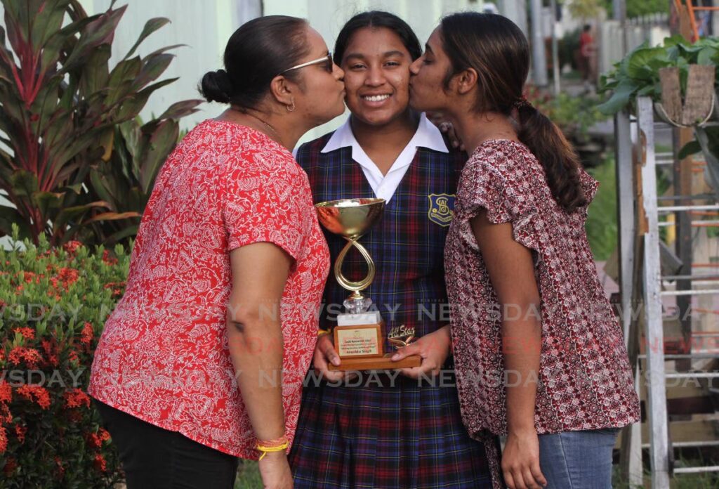 Anushka Singh, centre, gets a kiss from her mother Nadia, left, and her sister Ananda. - Angelo Marcelle