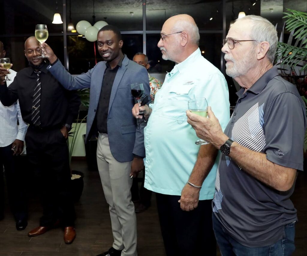 Chief Secretary Farley Augustine, second from left, toasts to the success of Kitchen Creole restaurant, as owner Jeffrey Azar, second from right, looks on, on opening night at Shirvan Plaza. - THA