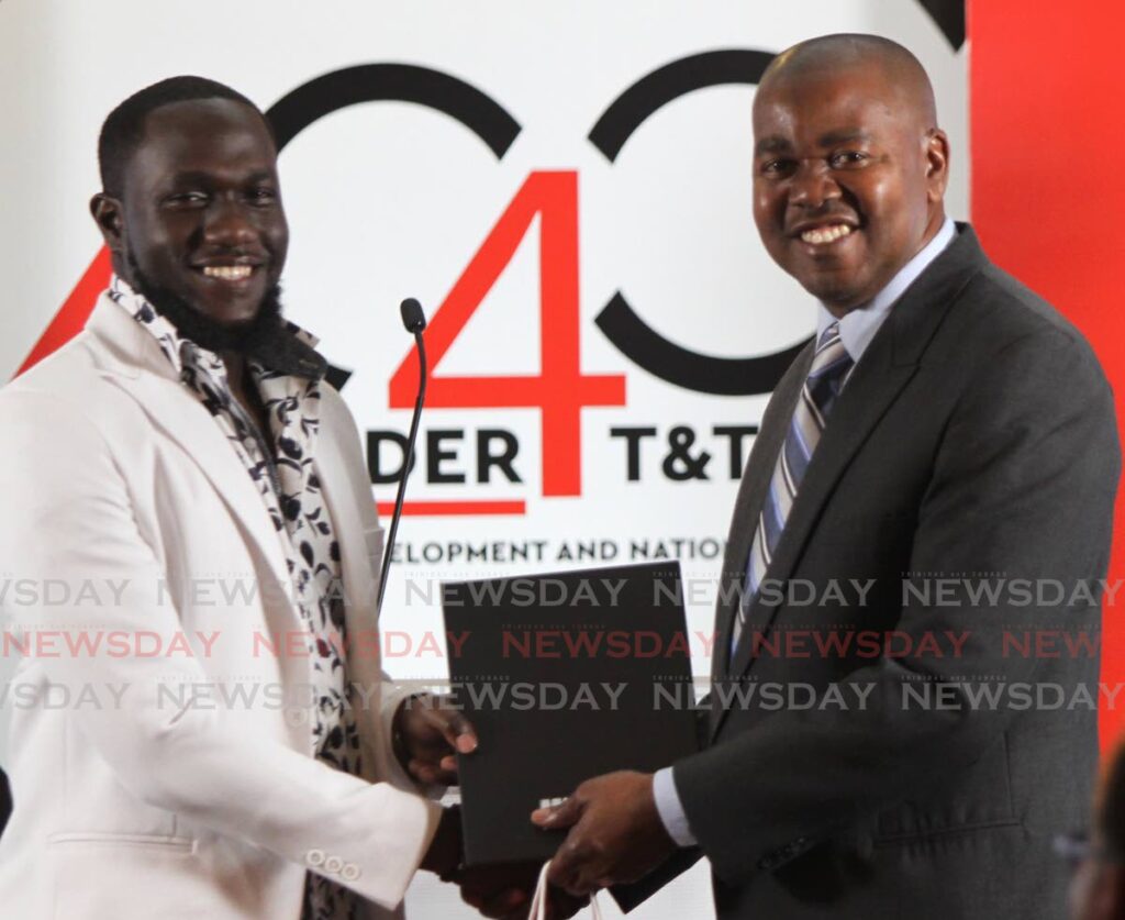 Brandon Best receives his instrument of appointment as a Youth Influencer from Youth Development and National Service Minister Foster Cummings at the re-launch of the ministry’s 40 Under 40 programme on Monday at Castle Killarney in Port of Spain. PHOTO BY ANGELO MARCELLE  - 