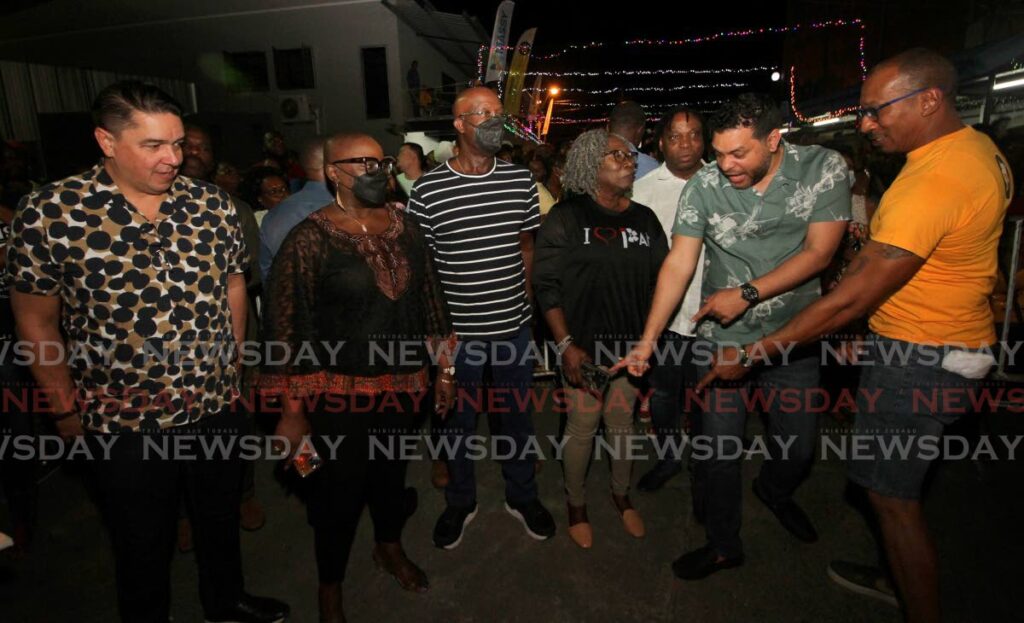 Prime Minister Dr Keith Rowley, centre, stands alongside Pan Trinbago president Beverly Ramsey-Moore, with government members, from left, Symon De Norbriga, Camille Robinson-Regis, Keith Scotland and Randall Mitchell at Massy Trinidad All Stars panyard on Tuesday night. An unidentified man is with the group. The PM later fell ill on Wednesday morning at the Oval where Invaders steelband was performing for judges. - Photo by Angelo Marcelle