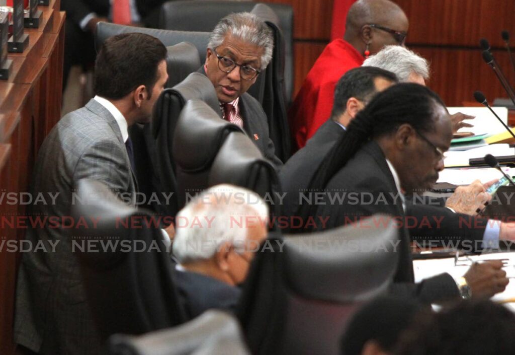 Minister of Rural Development and Local Government Faris Al-Rawi and Attorney General Reginald Armour chat during Friday's sitting of the Lower House. - AYANNA KINSALE
