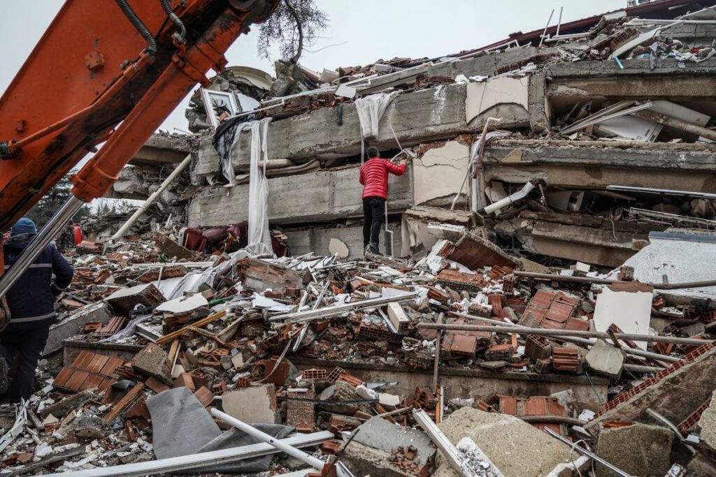 DEVASTATION: A man searches for people in the rubble of a destroyed building in Gaziantep, Türkiye on Monday. AP PHOTO - 