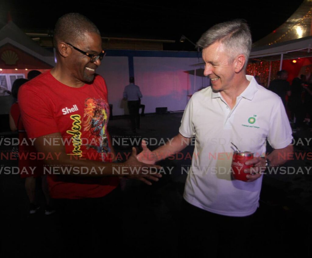Shell TT country chair and vice president Eugene Okpere and bpTT president David Campbell seem to shake on a bet of which band will win Panorama, Shell Invaders or BP Renegades, during Invaders sponsor's night at Queen's Park Oval, Port of Spain on Wednesday. - Angelo Marcelle