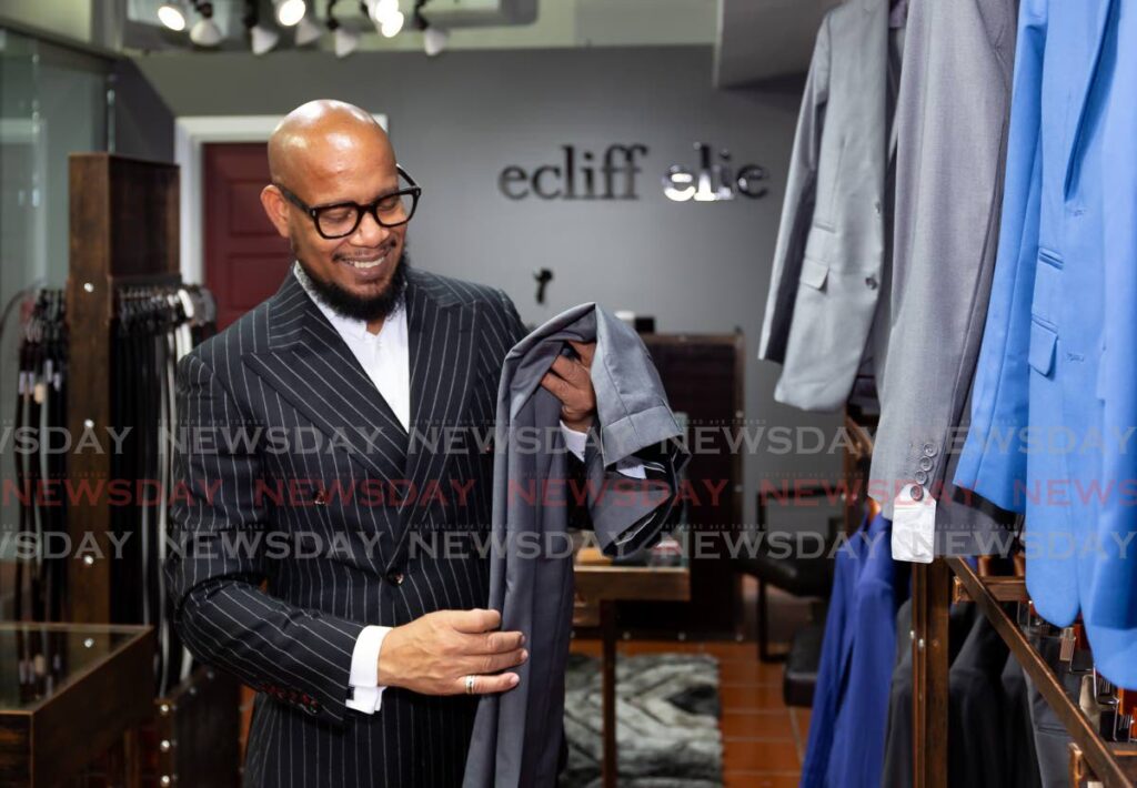 Designer Ecliff Elie with one of his dress pants on sale at his store in Crown Point, Tobago. Photo by David Reid