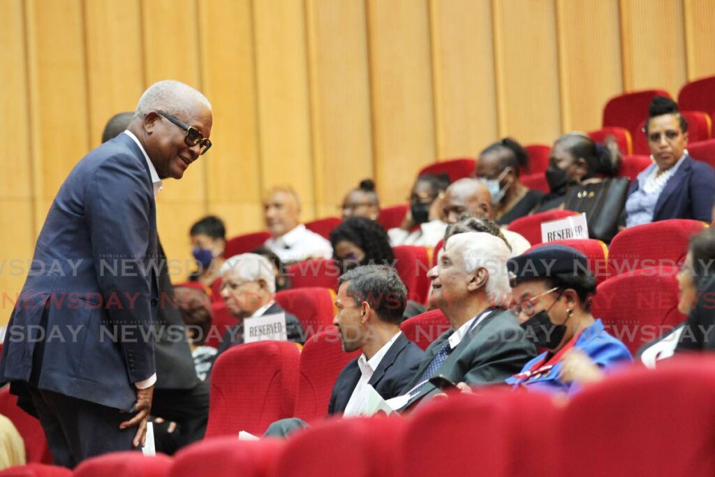 Former NAR government attorney general Anthony Smart, standing, speaks with former NAR government colleague Winston Dookeran, seated, front row 2nd from right, during the funeral for their ex-government colleague Jennifer Johnson at SAPA in San Fernando on Thursday.