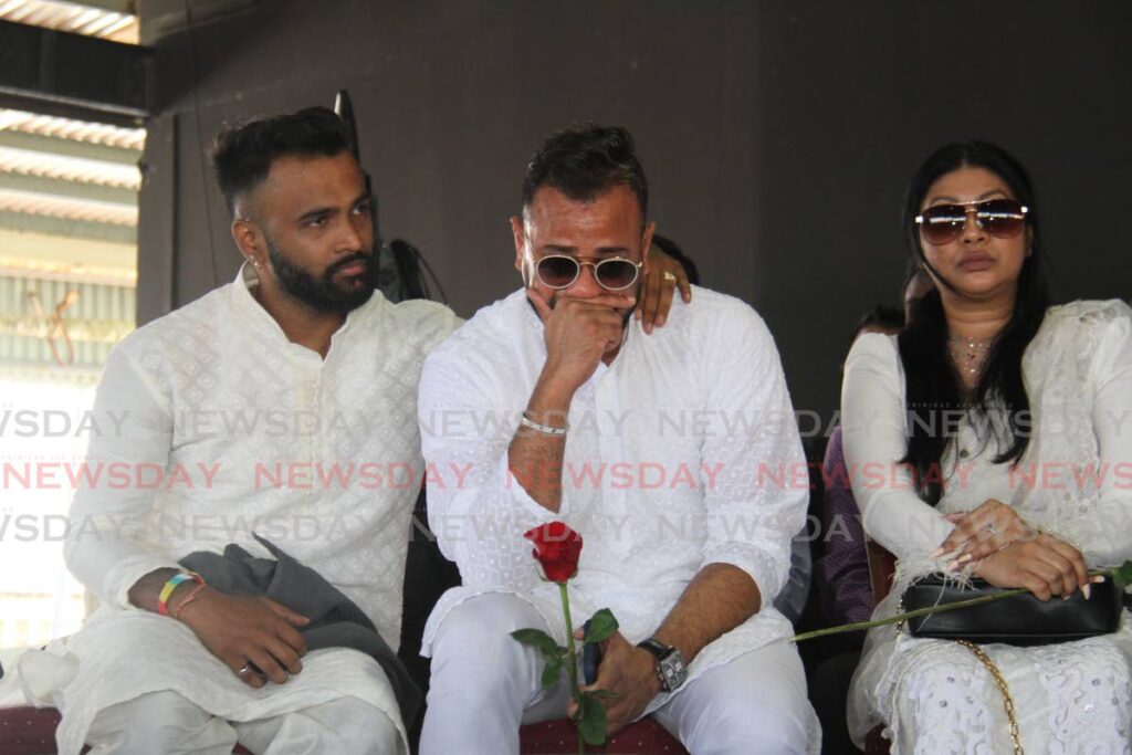 OVERCOME: Chutney singer Ravi B, centre, was inconsolable at the funeral for his friend and fellow artiste Anil Bheem on Thursday.