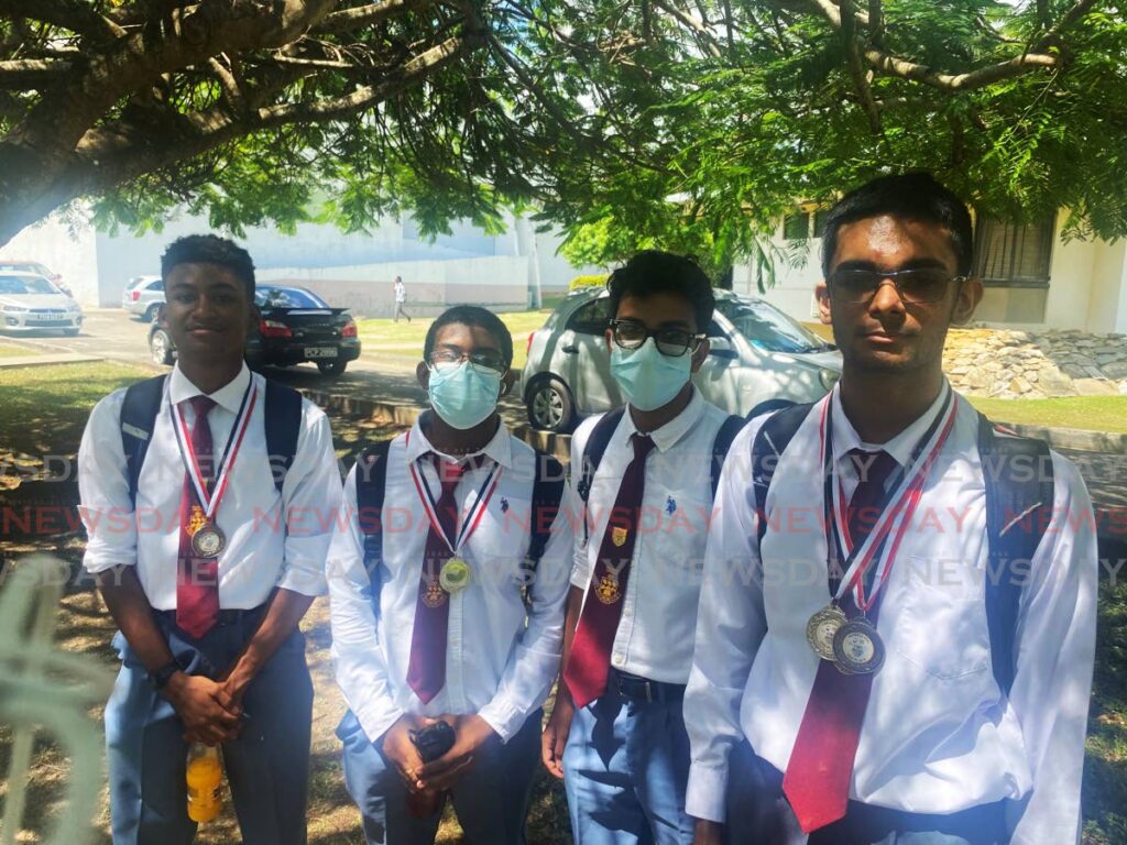 MATH BLING: Hillview College students from left, Samuel Blache, Keston Lewis, Rajesh Sharma and Jibril Persaud show off their medals at the UWI Math Fair held at the JFK Auditorium, UWI St Augustine campus on Thursday. 