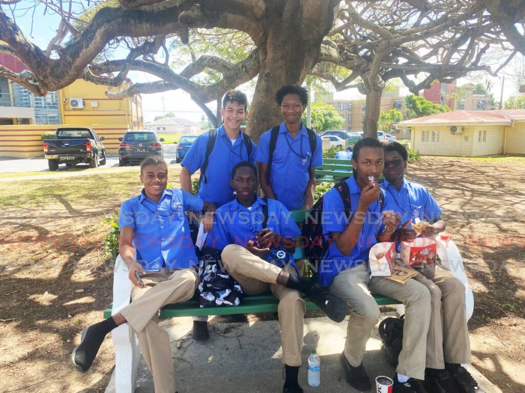JUST CHILLING: QRC students relax under a tree in UWI, St Augustine campus after participating in the UWI Math Fair held at the JFK Auditorium on Thursday.
