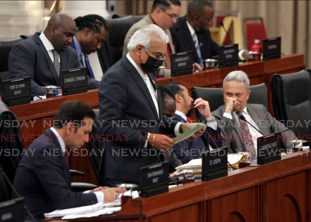 Local Government Minister Faris Al-Rawi, from left, goes over notes as Health Minister Terrence Deyalsingh makes a statement in the House of Representatives, while Energy Minister Stuart Young and Finance Minister Colm Imbert have a discussion on Friday. - Angelo Marcelle