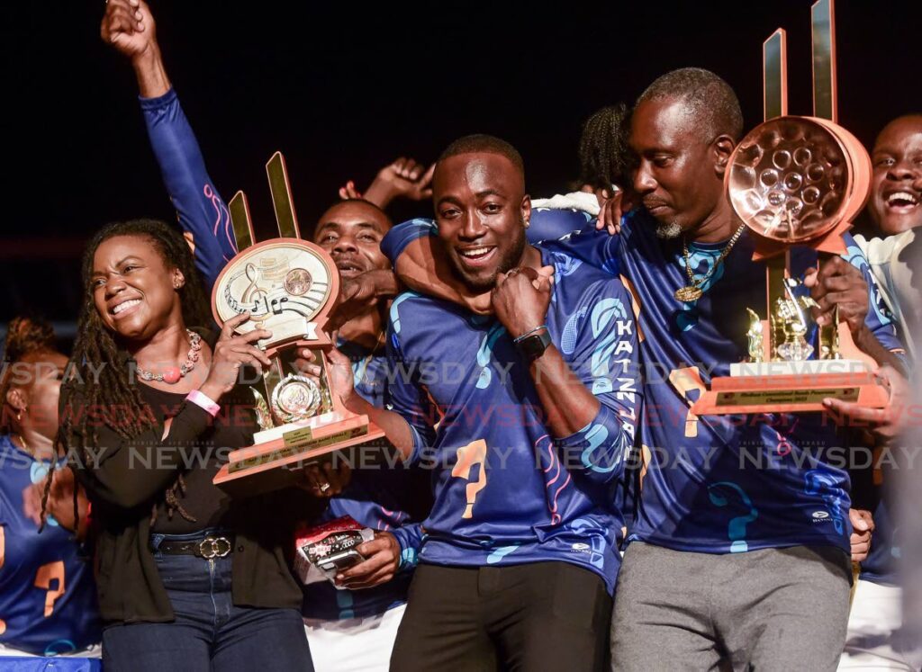 Secretary of Tourism and Culture Tashia Burris, left, presents the trophy to Kersh Ramsey, centre, arranger for Katzenjammers, who won the Panorama medum conventional bands finals on Sunday at Parade Grounds, Dwight Yorke Stadium, Bacolet. Photo by David Reid