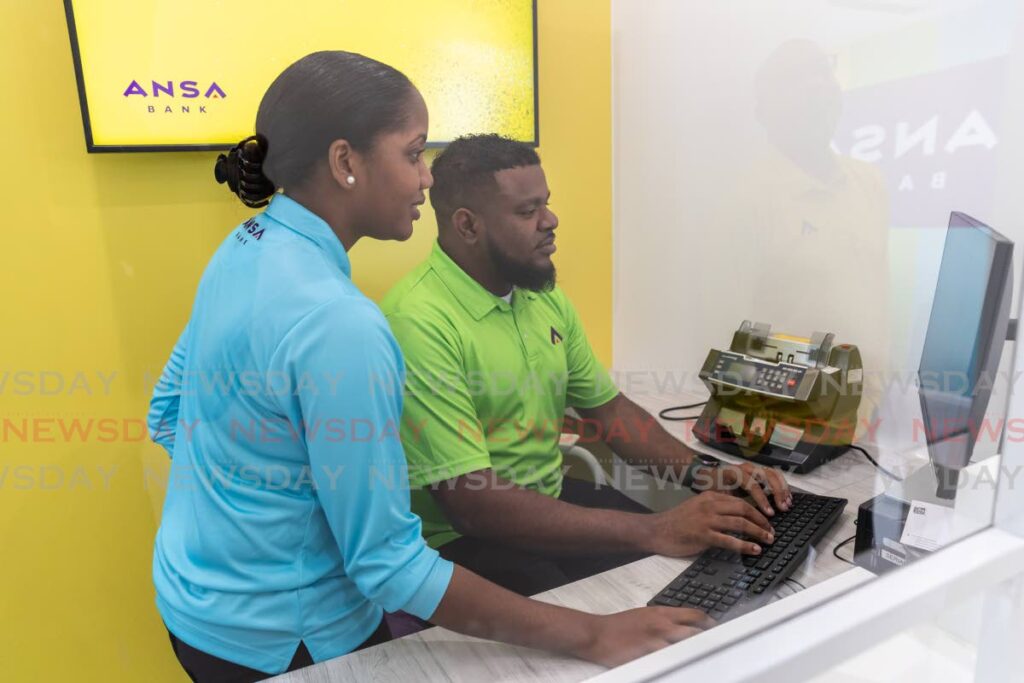 Ansa Bank staff using the digital system at its new touchpoint at Gulf City Mall, La Romaine. - 