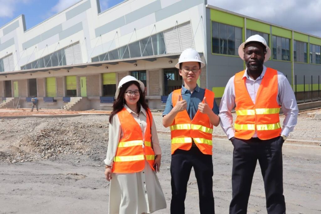 Sekou Alleyne, president InvesTT, with Michael Chen and Sera Huang of Summit (TT) Luggage Co Ltd at the company's factory, Phoenix Park Industrial Estate, Couva. - 