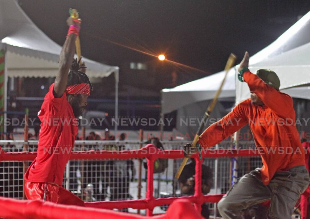 Eventual champion Selwyn Joseph John, left,  battles with Evon Ralph who placed second at the National Stick Fighting Finals in Skinner Park, San Fernando, on Wednesday night. - Marvin Hamilton