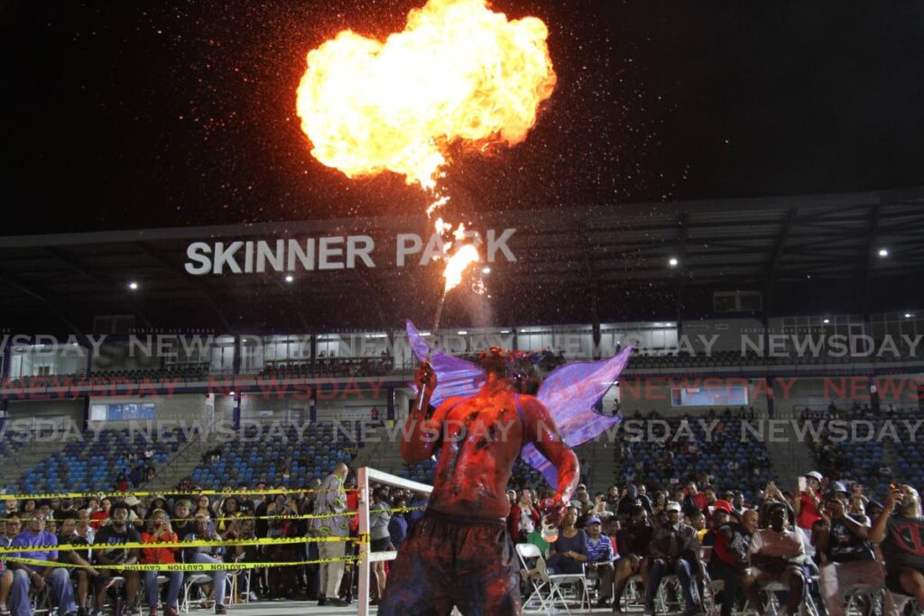 A blue devil breathes fire at the National Stick Fighting Finals, in Skinner Park, San Fernando on February 15. - Marvin Hamilton
