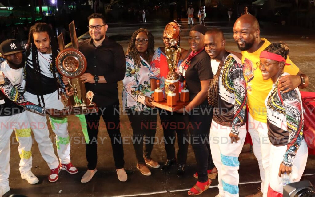 bp Renegades manager Colin Greaves, second from right, and members of his band pose with the winning trophies for Panorama’s large band category on Saturday night. Also in photo are Culture Minister Randall Mitchell, third from left, Pan Trinbago president Beverly Ramsey-Moore, centre, and CEO of Trinidad Tourism Ltd Carla Cupid, fourth from right. - Roger Jacob