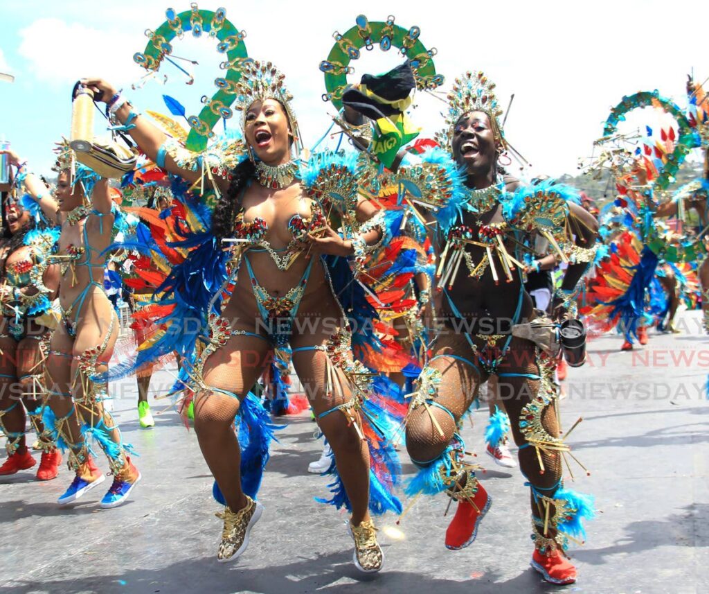 Masquerader from Yuma's Awakened Treasure enjoy themselves while crossing the stage at the Queen's Park Savannah, Port of Spain, on Tuesday. Photo by Ayanna Kinsale